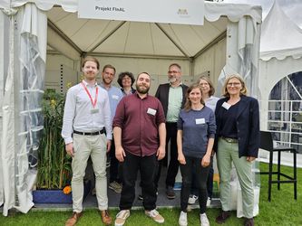 Forschende des Projektverbundes FInAL vor ihrem Ausstellungsstand bei der Woche der Umwelt 2024.