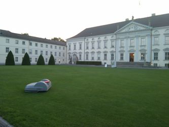 Mähroboter auf der vorderen Rasenfläche des Schlosses Bellevue, Berlin