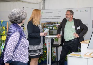 Jens Dauber, TI, Projektleiter FInAL, und Tanja Rottstock, Leitung FInAL am JKI, im Gespräch mit einer Vertreterin des BMEL am Stand von FInAL.